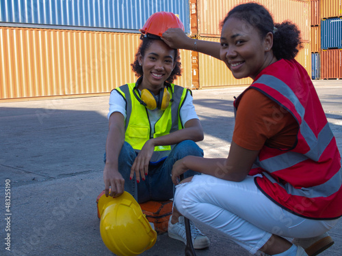 Female employe engineer african black skin wear hardhat helmet male business supervisor manager logistic container trade cargo work job career import export commercial technology digital industry