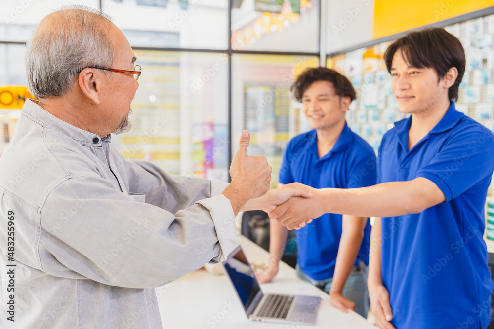 Customer satisfied to sales staff service finish deal good price and shake hands together.