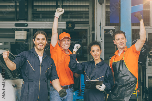 group of mechanic staff car service team worker people in garage happy smile hand risign photo