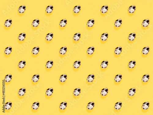 The easter background with the quail brown eggs pattern on the trendy yellow background.