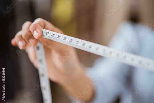 hand holding tape measure for making a dress