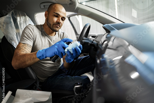 A man cleaning car interior, car detailing in Carwash service