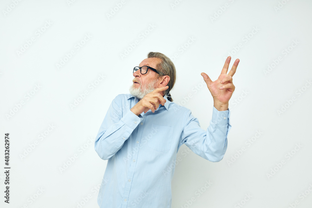 Photo of retired old man in blue shirts gestures with his hands cropped view