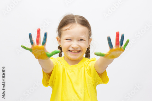 Happy cute little girl with colorful painted hands isolated on a white education concept