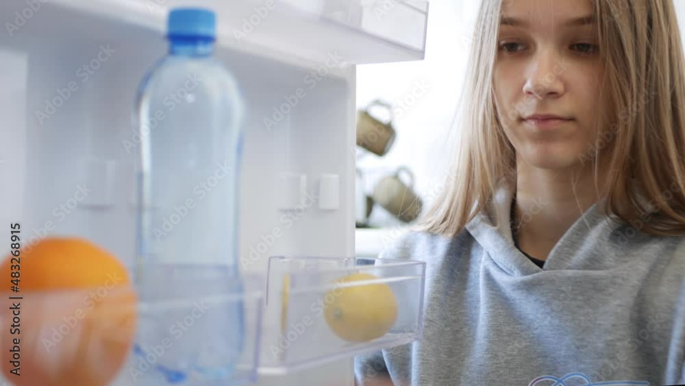 Child Opening Fridge, Girl Taking an Orange Fruits in Refrigerator, Kid Looking for Food in Poor Empty Freezer Poverty in Kitchen Child Opening Fridge, Girl Taking an Orange Fruits in Refrigerator, Kid Looking for Food in Poor Empty Freezer Poverty in Kitchen