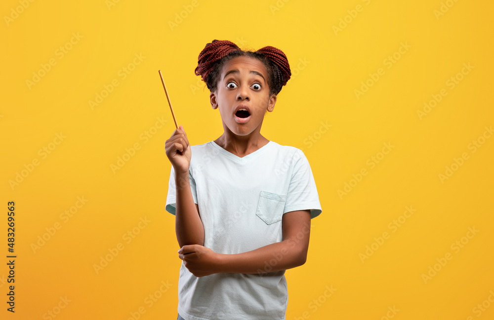 Amazed black girl teenager raising pencil up Amazed black girl teenager raising pencil up
