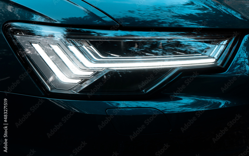Glowing headlight of a modern car close-up. Car LED lamp headlight detail. Modern car exterior details.