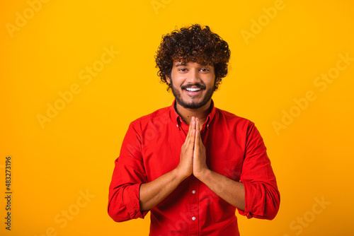 Фотография Young bearded man folding hands in prayer, closing eyes and talking to god, asking for help, expressing gratitude