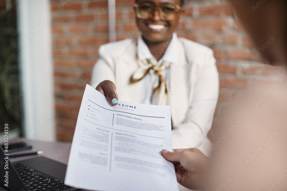 © Drazen - Close-up of black businesswoman gives her resume during job interview in the office. © Drazen - Close-up of black businesswoman gives her resume during job interview in the office.
