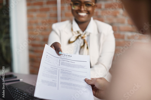 Close-up of black businesswoman gives her resume during job interview in the office. photo