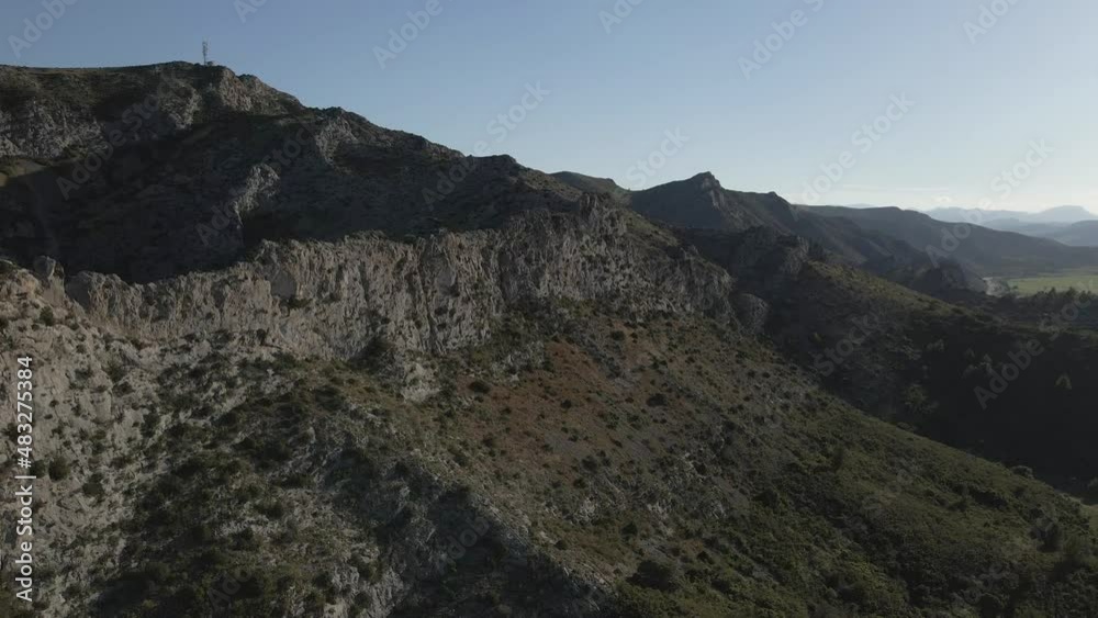 High limestone cliffs rise steep from fertile green valley in France High limestone cliffs rise steep from fertile green valley in France