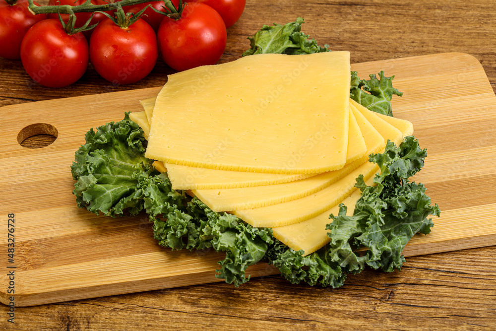 Sliced Gauda cheese over board Sliced Gauda cheese over board