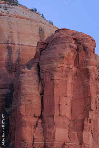 Large orange red rock formations and vistas of desert plants leading to mountains and valleys in Sedona, Arizona adds to the beauty of the wilderness