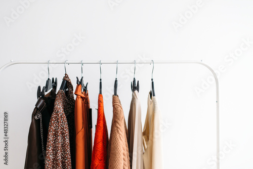 Bright fashion clothes on a rail over white background Fashion concept