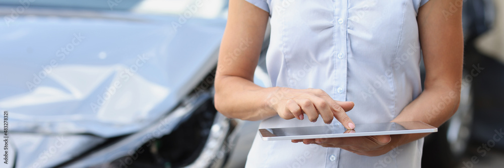Female insurance agent enters data into car damage program