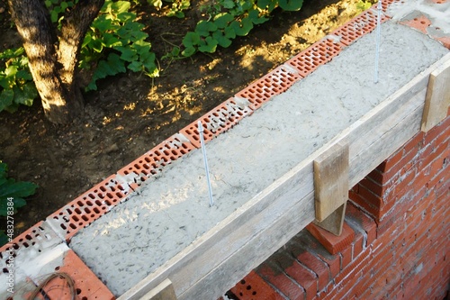 Self-made reinforced concrete lintel in country house under construction. Wooden formwork Close-up. Outer facing masonry above window is made on reinforced metal corner. photo