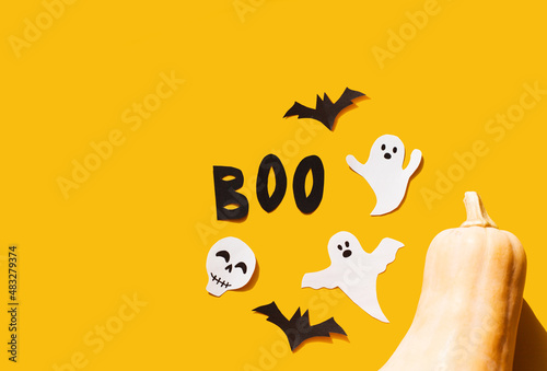 Halloween set decorations with ghost  bat  pumpkin  skeleton and word BOO on yellow background. Holiday party  minimal greeting card  spooky concept. flat lay  copy space  top view  place for text