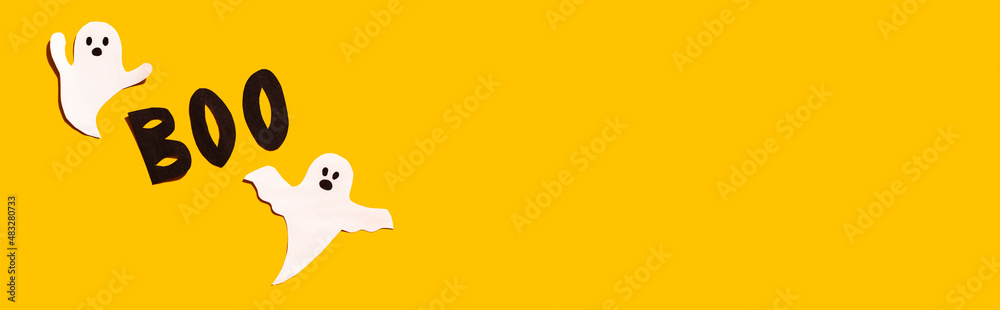 Halloween set decorations with ghost and word BOO on yellow background. Holiday party, minimal greeting card, spooky concept. flat lay, copy space, top view, place for text, banner Halloween set decorations with ghost and word BOO on yellow background. Holiday party, minimal greeting card, spooky concept. flat lay, copy space, top view, place for text, banner