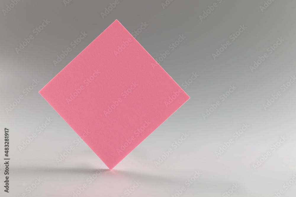Pink sticker standing on sharp edge on grey background Pink sticker standing on sharp edge on grey background