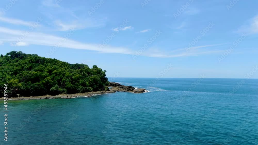 Rocky cape covered with lush tropical forest on coast of Java island, Indonesia, aerial view Rocky cape covered with lush tropical forest on coast of Java island, Indonesia, aerial view
