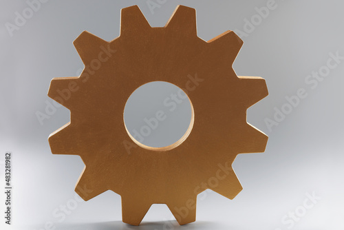 Large wooden gear on grey background, single mechanism for integrated development photo
