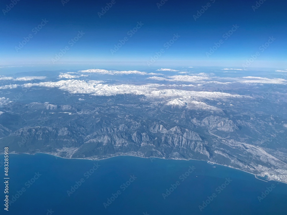 Beautiful landscape of the planet earth with mountains, water and blue sky. Great view from the plane