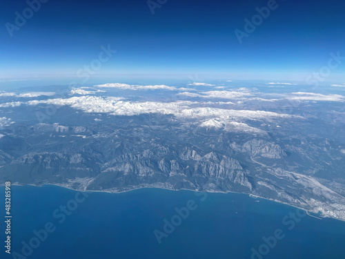 Beautiful landscape of the planet earth with mountains, water and blue sky. Great view from the plane