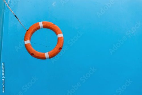 Orange lifebuoy floats on blue water in the sea. Help and protection of life. Summer vacation
