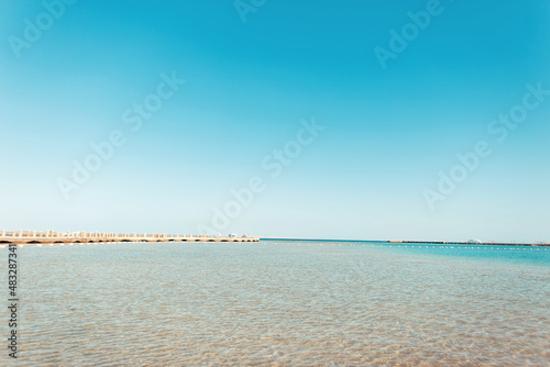 Beautiful sea view with clear azure water, pier, yacht and blue sky. Summer vacation on the Red Sea in Africa