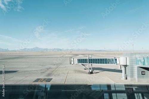 Beautiful airport and boarding terminal bridge with mountains and blue sky. Travel concept. Nobody