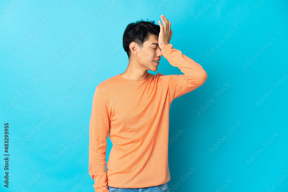Young Chinese man isolated on blue background has realized something and intending the solution Young Chinese man isolated on blue background has realized something and intending the solution