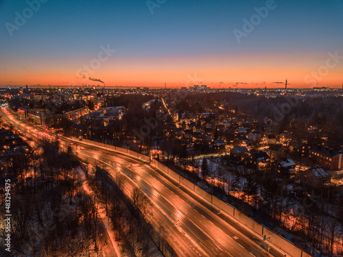 Panoramic sunset at winter over the city of Helsinki, highway at night, traffic in the city