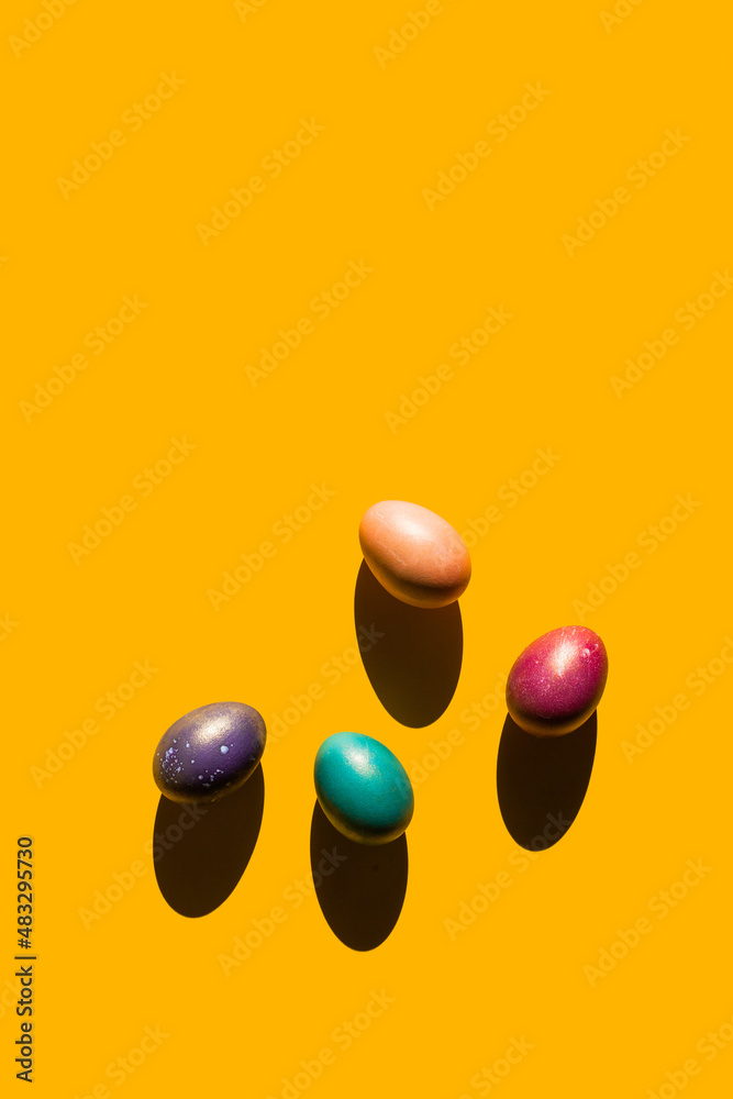 Happy Easter holiday concept. Set of handmade colorful eggs isolated on yellow background with shadow. Simple trendy minimal composition, flat lay, top view, copy space, place for text, banner Happy Easter holiday concept. Set of handmade colorful eggs isolated on yellow background with shadow. Simple trendy minimal composition, flat lay, top view, copy space, place for text, banner
