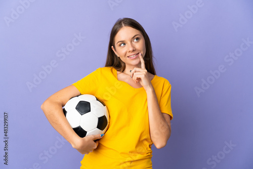 Young Lithuanian football player woman isolated on purple background thinking an idea while looking up © luismolinero