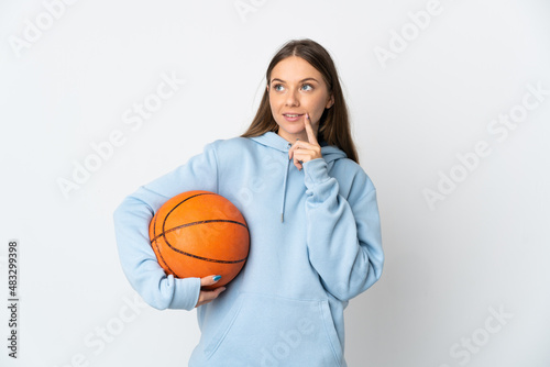 Young Lithuanian woman playing basketball isolated on white background thinking an idea while looking up