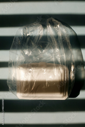 Close up white styrofoam lunch box inside transparent plastic bag