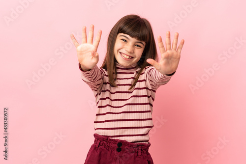 Little girl isolated on pink background counting nine with fingers