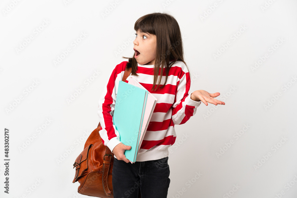 Little student girl isolated on white background with surprise expression while looking side Little student girl isolated on white background with surprise expression while looking side