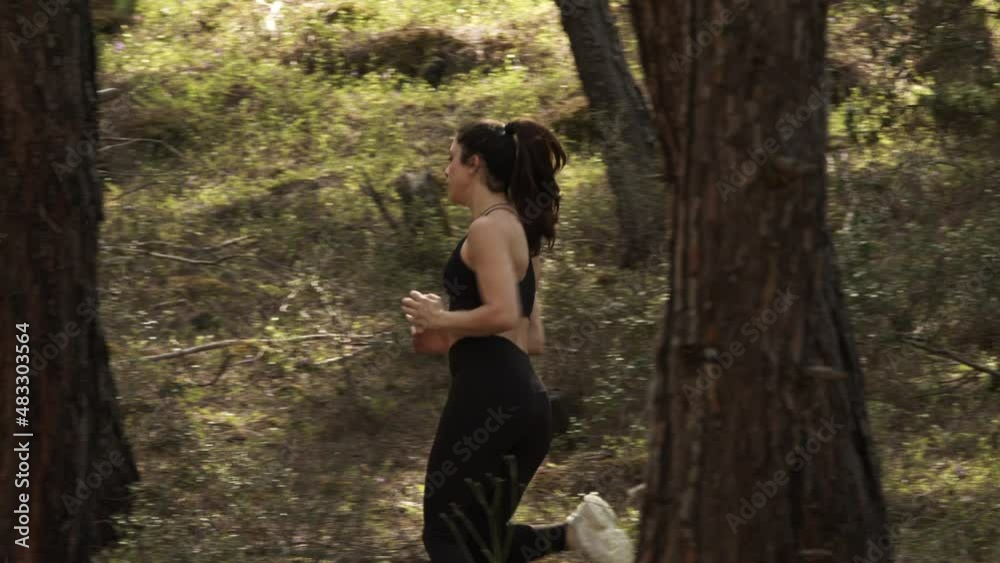 Action shot of girl in black clothes running in the woods Action shot of girl in black clothes running in the woods