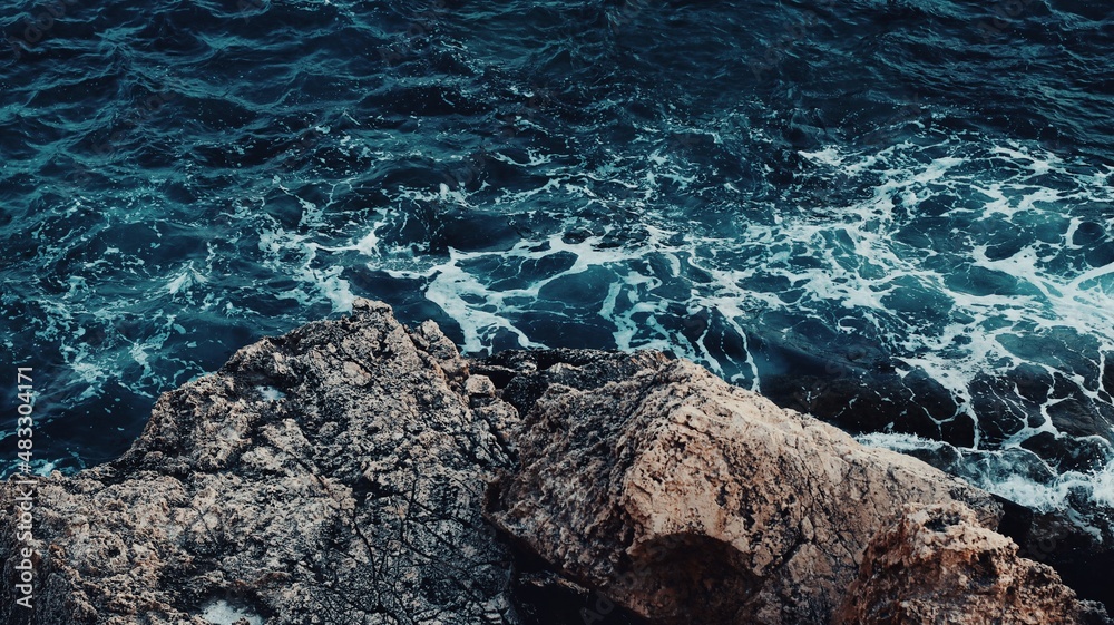 Background sea waves break on the rocks