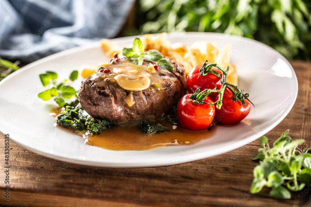 Juicy steak with sauce served with vegetable on a well presented plate Juicy steak with sauce served with vegetable on a well presented plate