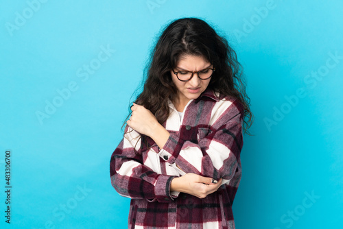 Teenager Russian girl isolated on blue background with pain in elbow © luismolinero