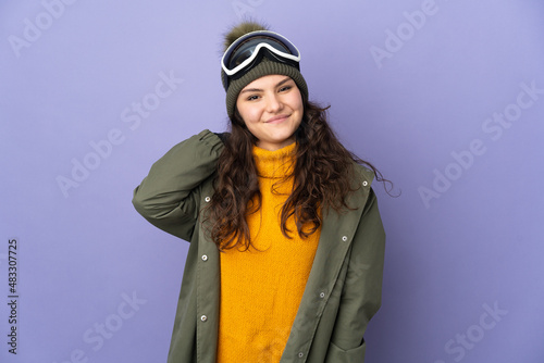 Teenager Russian girl with snowboarding glasses isolated on purple background laughing