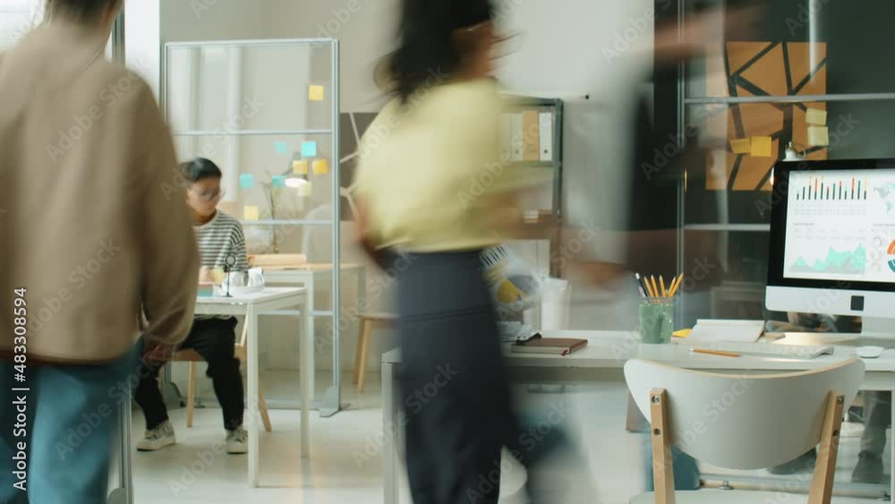 Time lapse of business people walking, using computers and working with documents during day in office