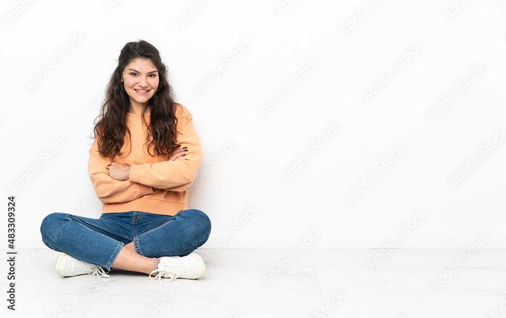 Teenager Russian girl sitting on the floor laughing Teenager Russian girl sitting on the floor laughing