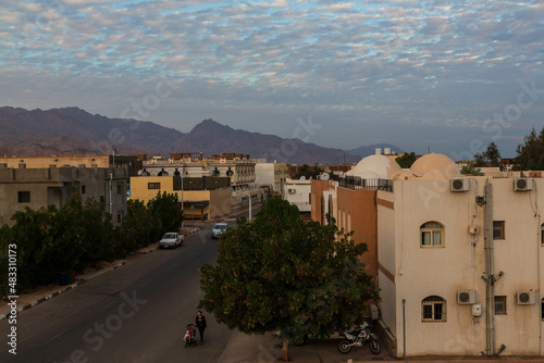 Fotografía Local houses, beautiful cloud in the sky, mountains on the horizon during sunset