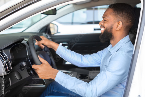Buying Auto. Black Man Sitting Inside Of Car And Holding Steering Wheel © Prostock-studio