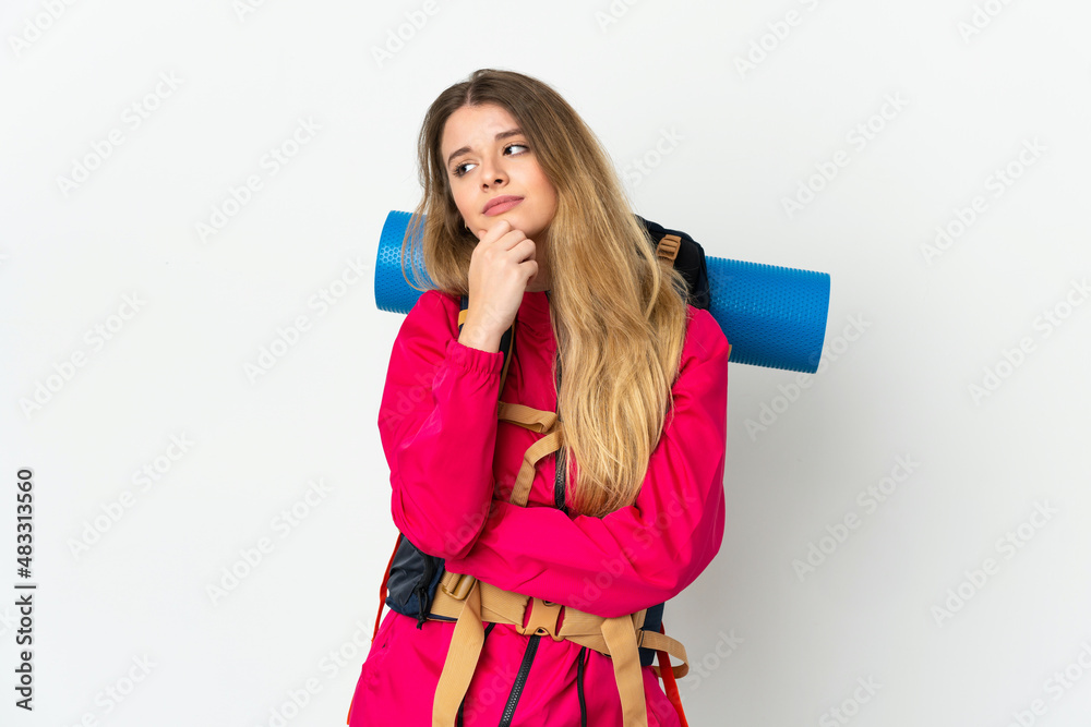 Young mountaineer woman with a big backpack over isolated background having doubts Young mountaineer woman with a big backpack over isolated background having doubts