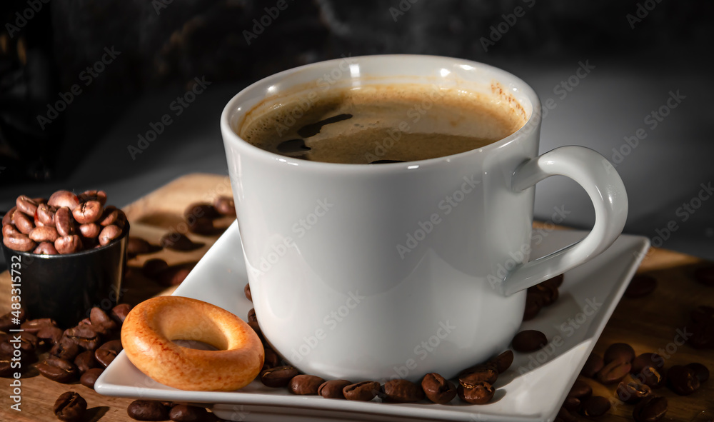 White cup and saucer of espresso coffee close-up on a dark background. Black espresso coffee. White cup and saucer of espresso coffee close-up on a dark background. Black espresso coffee.