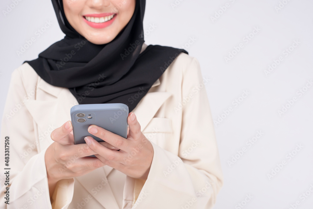 Portrait of young beautiful muslim woman in suit using smart phone over white background. Portrait of young beautiful muslim woman in suit using smart phone over white background.